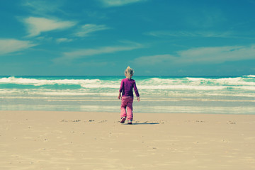 4 years old girl playing on the beach