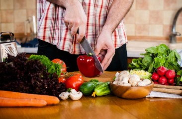 Man cuts fresh spring vegetables