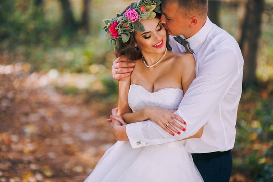 happy bride and groom walking in the autumn forest