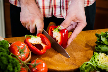 Man cuts fresh spring vegetables