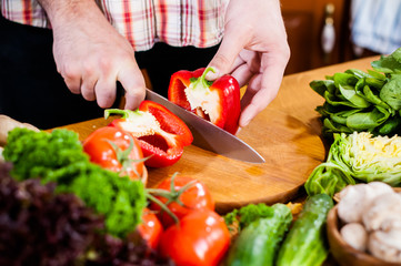 Man cuts fresh spring vegetables