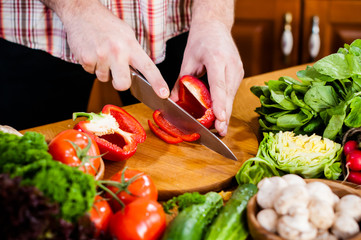 Man cuts fresh spring vegetables