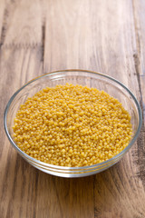 couscous in bowl in brown background