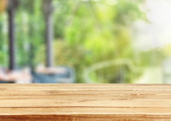 Wood. Empty tropical wood table and blurred garden cafe light
