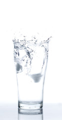 Fototapeta na wymiar Ice drop into Glass of Water on White background