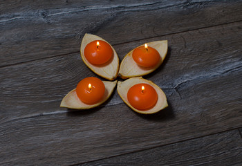 four round orange candle burning in the stands of the orange pee