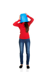 Woman with plastic bucket on head.