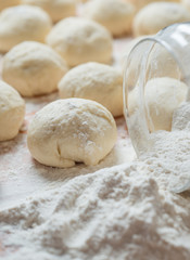 Fototapeta na wymiar balls of dough covered with wheat flour ready for baking