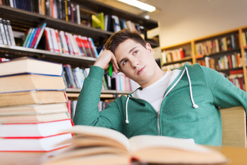 bored student or young man with books in library