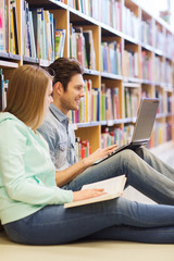 happy students with laptop in library