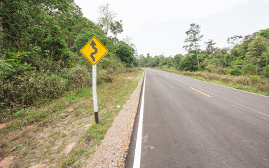 Curvy road sign to the mountain in rural area