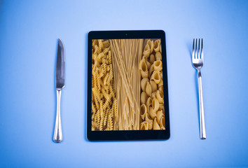 Tablet, knife, fork, and food
