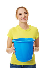 Young woman holding blue bucket.