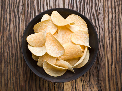 Potato chips on a wooden background.