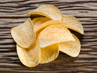 Potato chips on a wooden background.