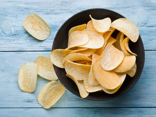 Potato chips on a wooden background.