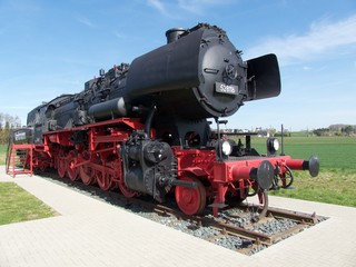 Alte schwarze Dampflokomotive der Deutsche Reichsbahn vor blauem Himmel im Sonnenschein in...