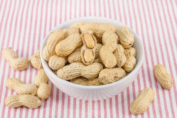 closeup of salted groundnuts in white bowl