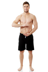 Fototapeta premium Sexy muscular man holding copyspace in hands.