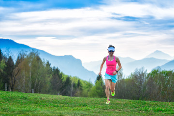 Obraz premium Blonde girl athlete runs in the mountains