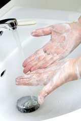 Man washes his hands in the sink