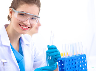 Woman researcher is surrounded by medical vials and flasks