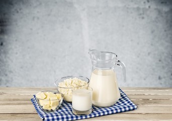 Milk. A glass of milk and a milk jug on plaid tablecloth.