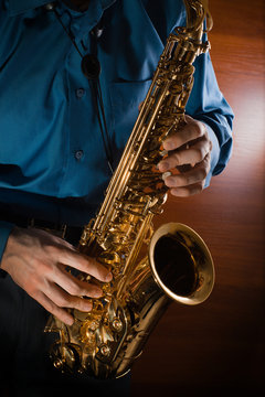Man playing jazz saxophone closeup. Golden sax.