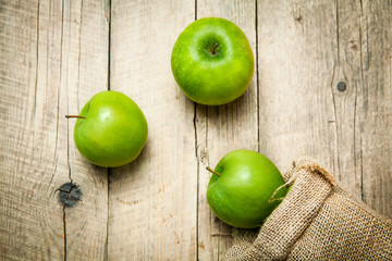 fruit. Ripe green apples with burlap, on wooden  background