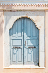 emerald door with arch frame on Santorini in Greece