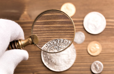 Examining old silver coin