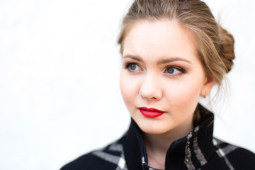 Fototapeta premium portrait of a beautiful girl in high key against a white wall