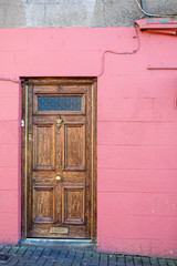 Fototapeta na wymiar Hintergrund - rosa Wand mit brauner Tür
