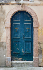 Stone portal and a wooden door to the church.