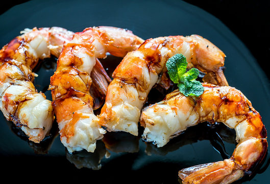 Fried shrimps with lemon wedges on the black background