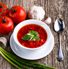 Borsch with bread on a wooden background.