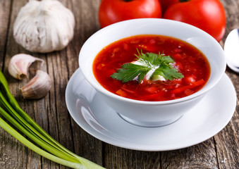 Borsch with bread on a wooden background.