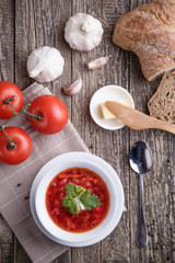 Borsch with bread on a wooden background.