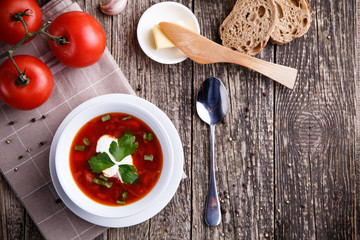 Borsch with bread on a wooden background.