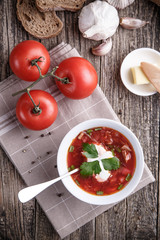 Borsch with bread on a wooden background.