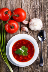 Borsch with bread on a wooden background.