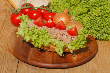 Fischbrötchen mit Thunfischfilet, Salat, Gewürzgurken, Zwiebeln