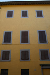 Fototapeta premium Facciata palazzo giallo con finestre e persiane