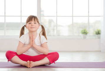 Smiling little girl in lotus position
