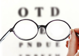 Eye glasses on eyesight test chart background