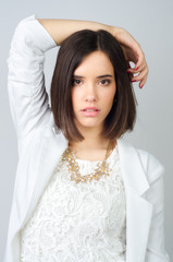 Beautiful elegant girl posing in studio isolated on gray 