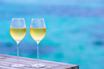 Two glasses of tasty white wine background the sea