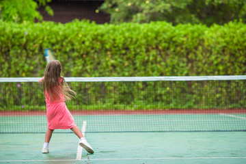 Little girl playing tennis on the court