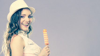 woman in summer hat eating ice pop cream