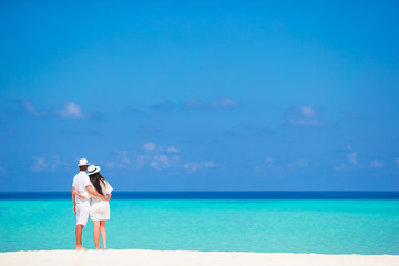 Back view of young couple on white beach at summer vacation